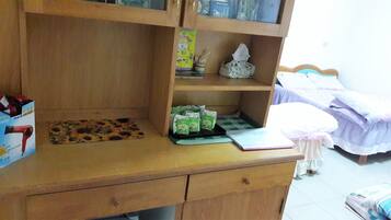 A wooden desk with a hair dryer, a notebook, and a tissue box.