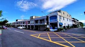 A street view with a building featuring a blue storefront and a sign with Chinese characters. - Hai Xia Your Home (New Taipei City)