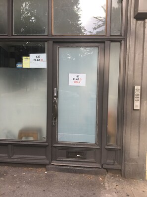A building entrance with a glass door marked "137 FLAT D ONLY".