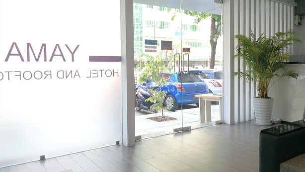 A hotel entrance with a glass door, a sign reading "AMAY HOTEL ROOFTOP", and a potted plant on the right. - Yama Hotel & Rooftop Bar (Yangon)
