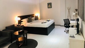 A modern bedroom with a large bed, a desk, and a chair. - Yama Hotel & Rooftop Bar (Yangon)