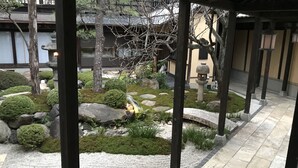 Ein traditioneller japanischer Garten mit Steinlaternen, einem Koiteich und ordentlich beschnittenen Sträuchern.