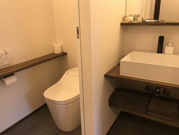 Un baño con inodoro, lavamanos y toallero.