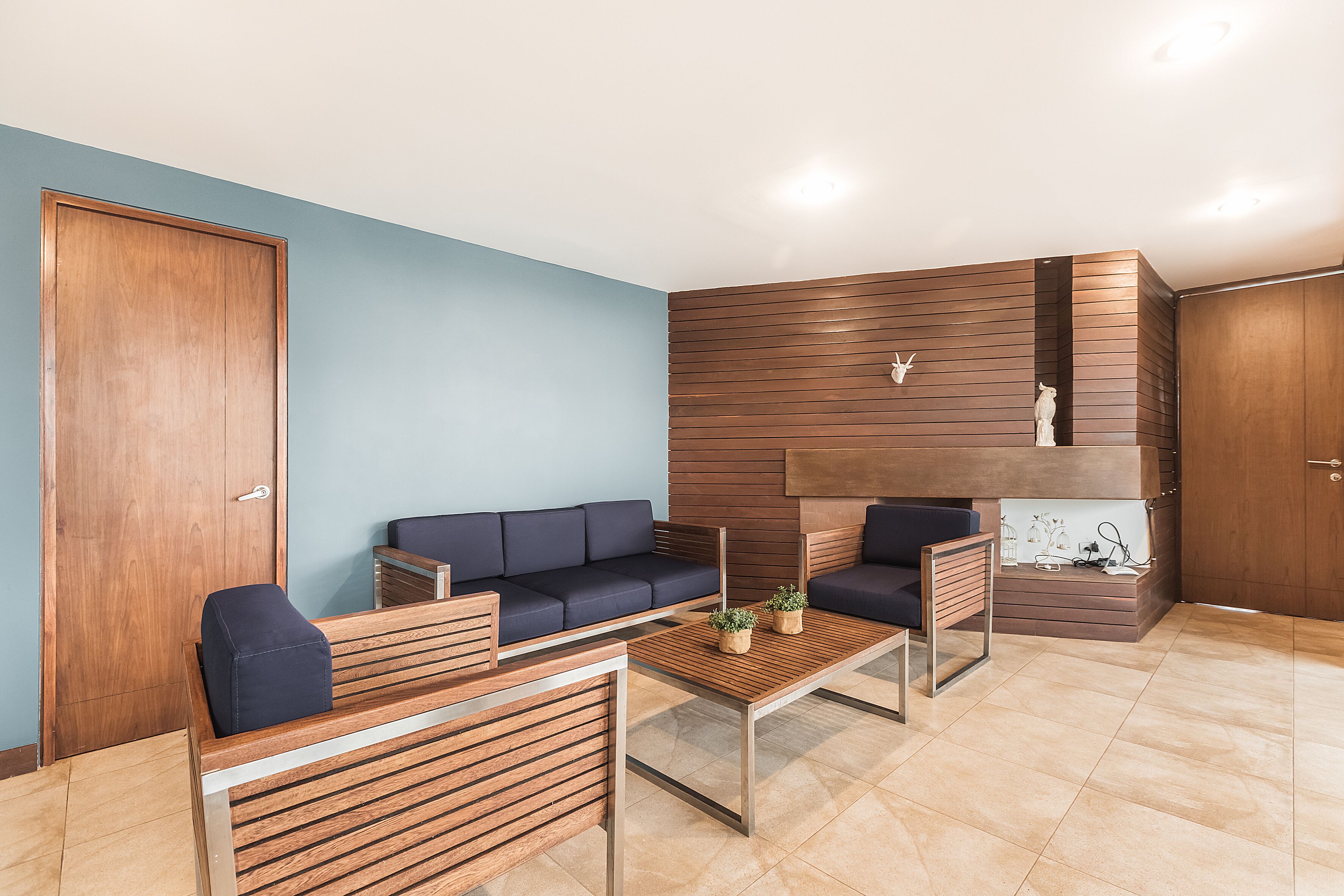 Una sala de estar moderna con sofá, mesa de centro y detalles de madera.