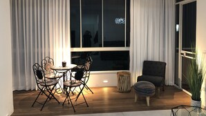 Un comedor con una mesa redonda y sillas, una mesita auxiliar y una silla.