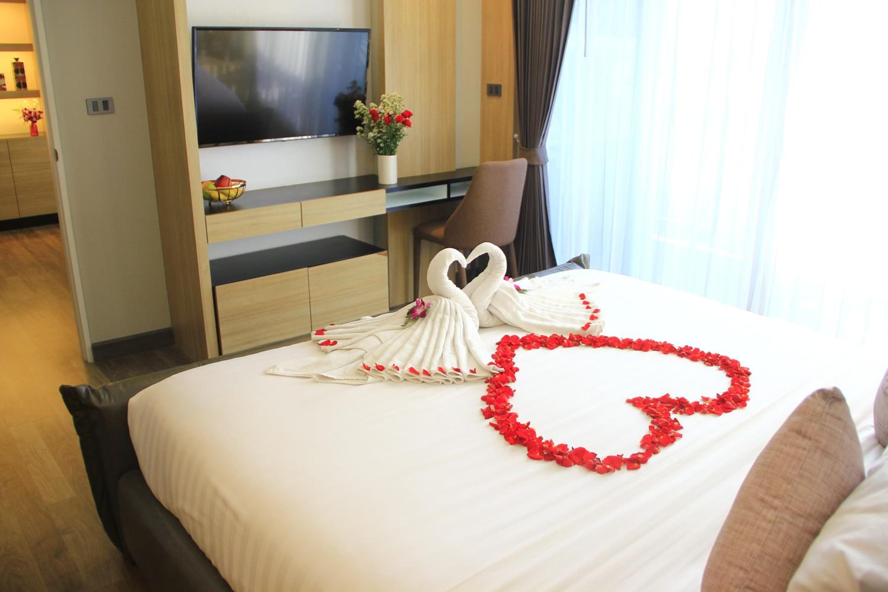 Een hotelkamer met een bed, een televisie, een bureau en een stoel.