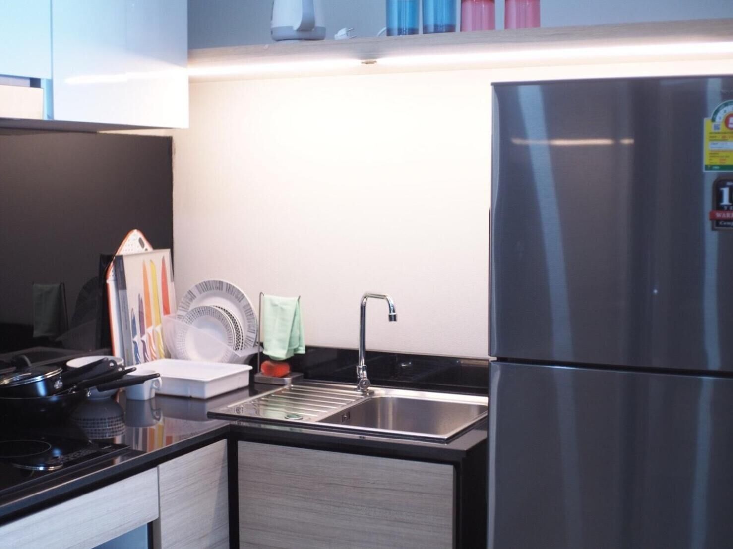 Een moderne keuken met een roestvrijstalen koelkast, een spoelbak en een kookplaat.