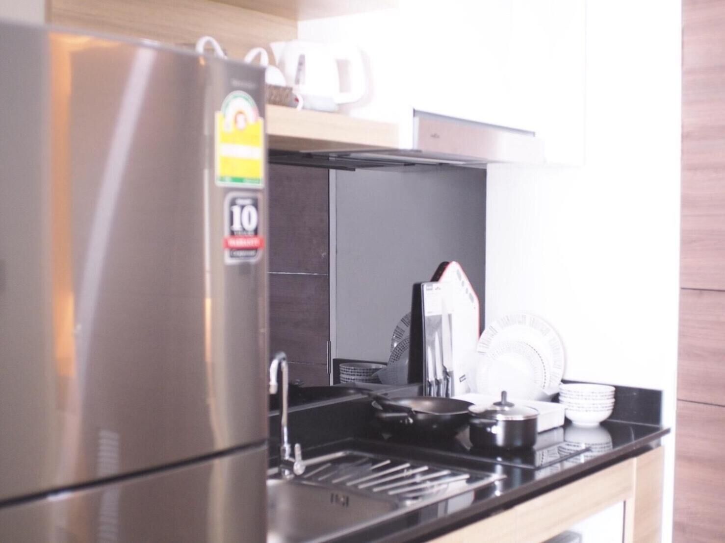 A kitchen with a stainless steel refrigerator, a microwave, and a stove.