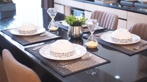 A dining table set with plates, cutlery, and decorative items in a modern kitchen.