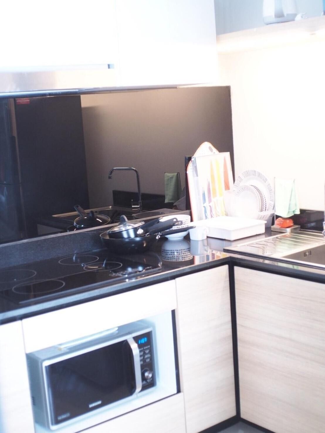 A kitchen with a stove, microwave, and a sink.