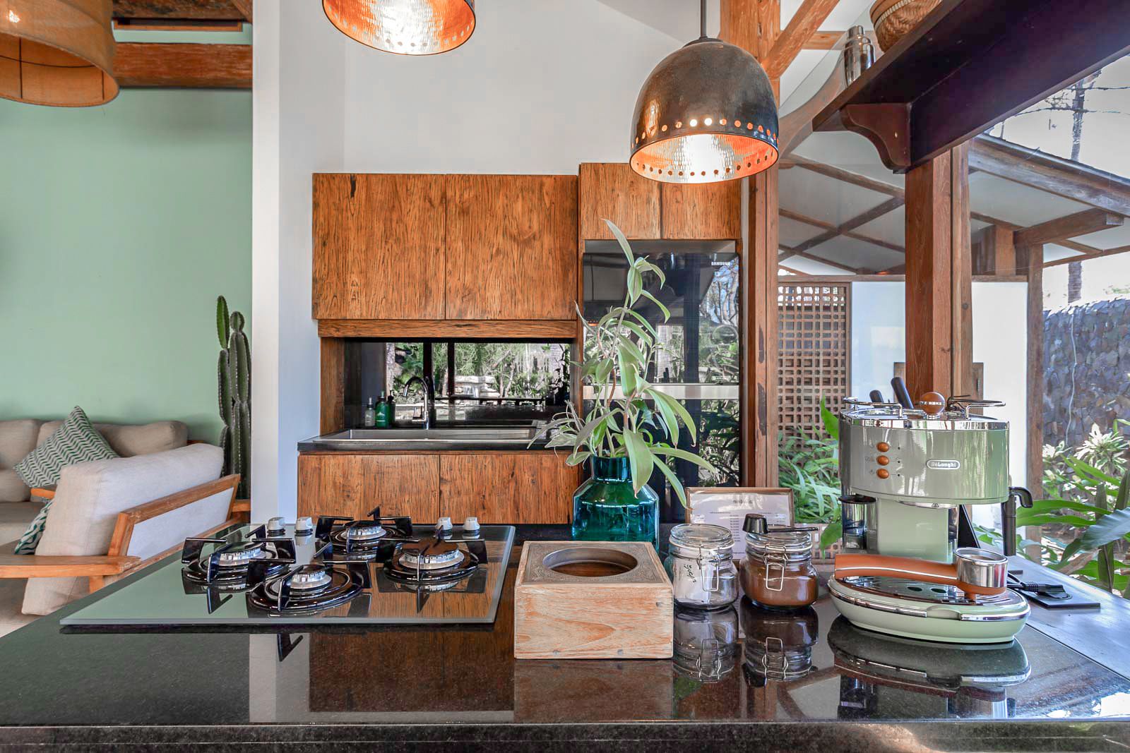 Une cuisine moderne dotée d’un îlot central, de meubles en bois et offrant une vue sur l’extérieur.