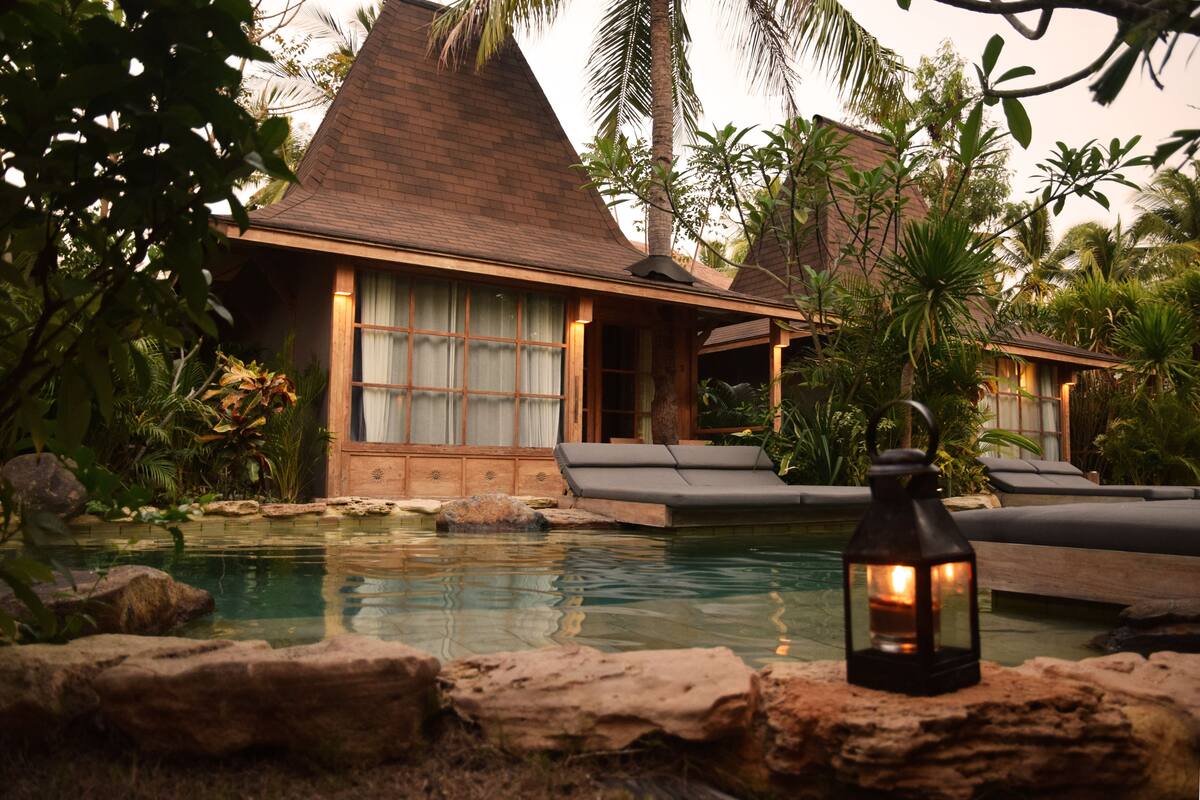 A resort with a pool, lounge chairs, and a lantern.