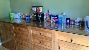 A kitchen counter with various food items and kitchen appliances.