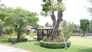 A well-maintained garden with a gazebo, neatly trimmed hedges, and a variety of trees. - Aranya Resort (Chumphon)