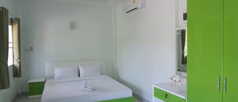 Un dormitorio con cama, mesita de noche, cómoda y equipo de aire acondicionado.