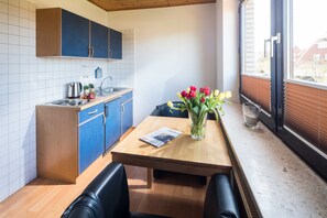 Una cocina moderna con armarios azules, una mesa de madera y un jarrón con tulipanes.