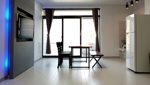Una cocina moderna con comedor, refrigerador y televisor de pantalla plana montado en la pared.