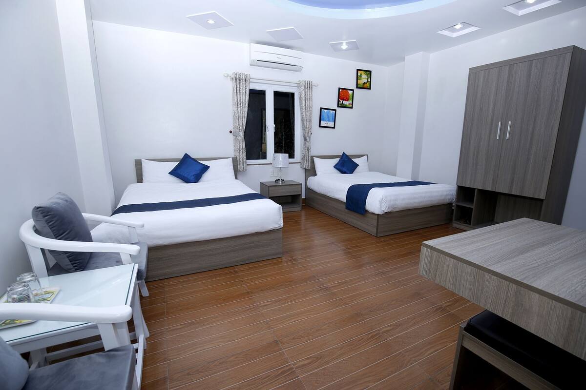 Een hotelkamer met twee bedden, een bureau, een stoel en een kledingkast.