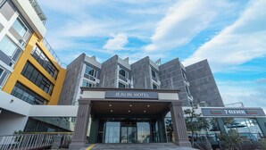 A hotel entrance with a modern design, featuring a prominent sign that reads 'JEJU IN HOTEL'. - Jeju IN Hotel (Jeju City)