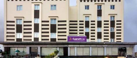Un edificio hotelero de dos pisos con un diseño moderno, que presenta un techo plano y una fachada simétrica con ventanas regularmente distribuidas.