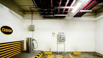 A parking garage with yellow and black striped barriers, a sign reading "CASION," and a sign with instructions.