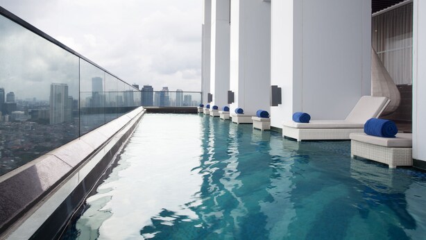 A rooftop infinity pool with lounge chairs and a city view. - Ascott Sudirman Jakarta (Jakarta)