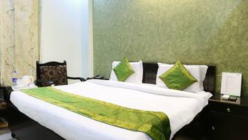 Una habitación de hotel con una cama bien hecha, una silla, una mesita de noche y una pared con un diseño texturizado.