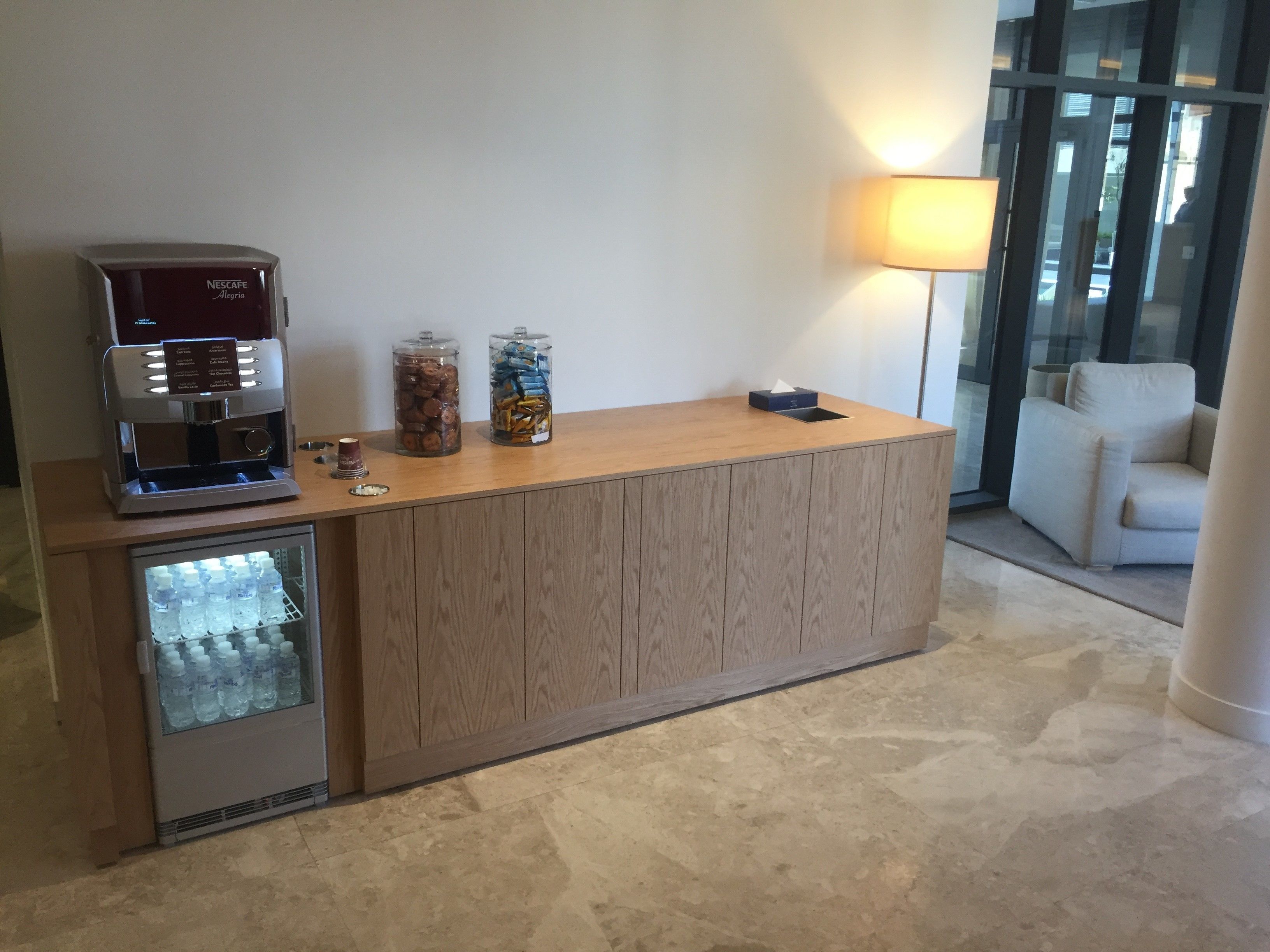 A reception desk with a coffee machine, snack dispensers, and a water cooler.