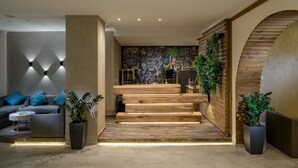 Un interior moderno con una escalera, un sofá y plantas en macetas.