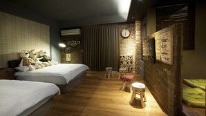 A hotel room with two beds, a small stool, a clock, and a wall with motivational quotes. - SpringTree B&B (Dongshan)