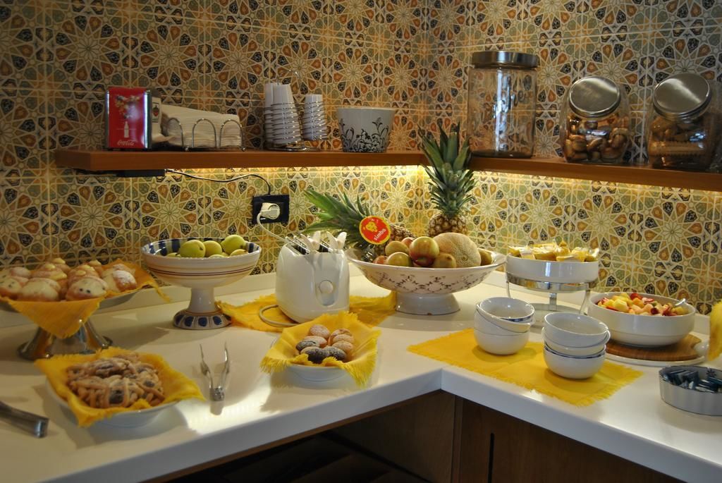 A buffet with various food items and a decorative wall with a geometric pattern.