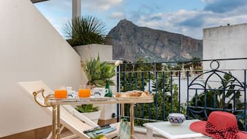 Suite junior, terraza, vistas parciales al mar | Ropa de cama de alta calidad, minibar, caja fuerte y escritorio