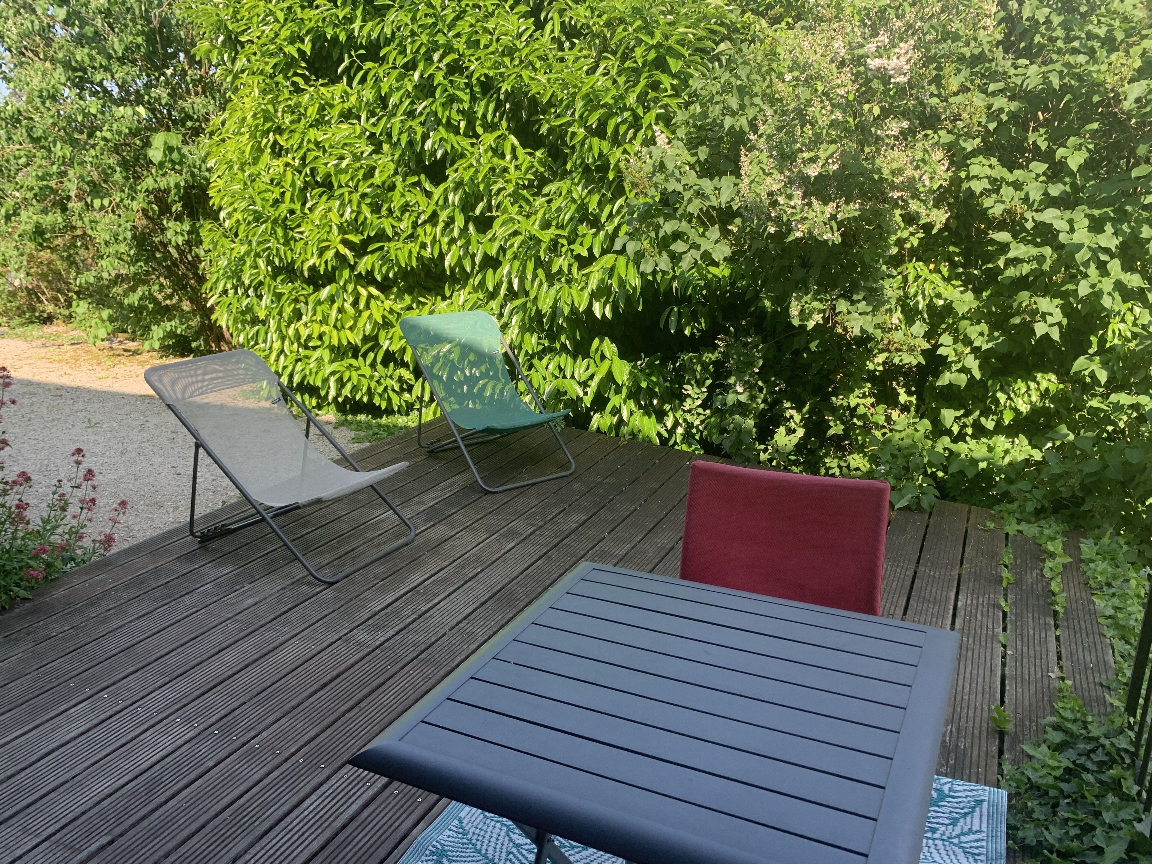 An outdoor deck with a table and two chairs.