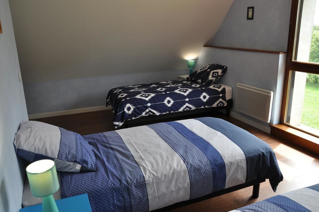 Un dormitorio con cama, mesita de noche, lámpara y ventana.