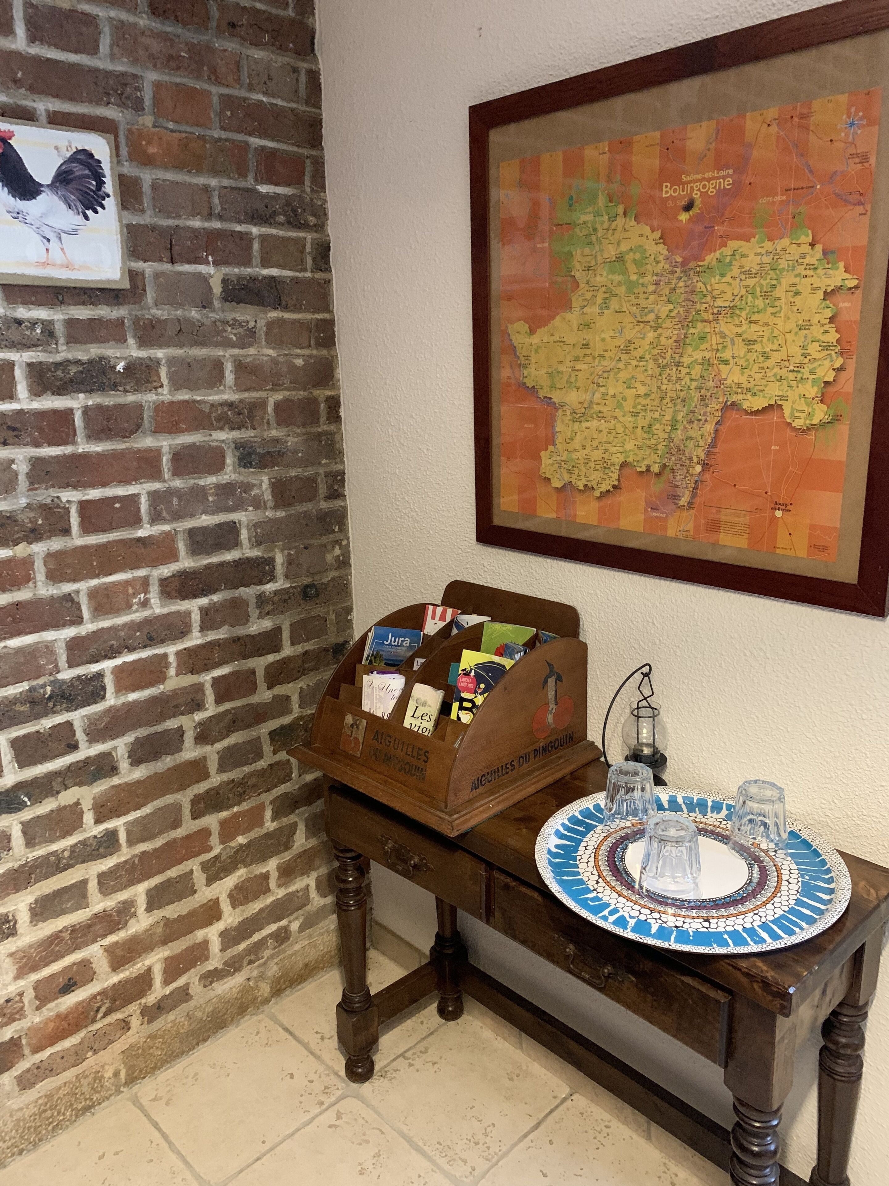 Un escritorio de madera con un mapa, un atril y un plato decorativo.