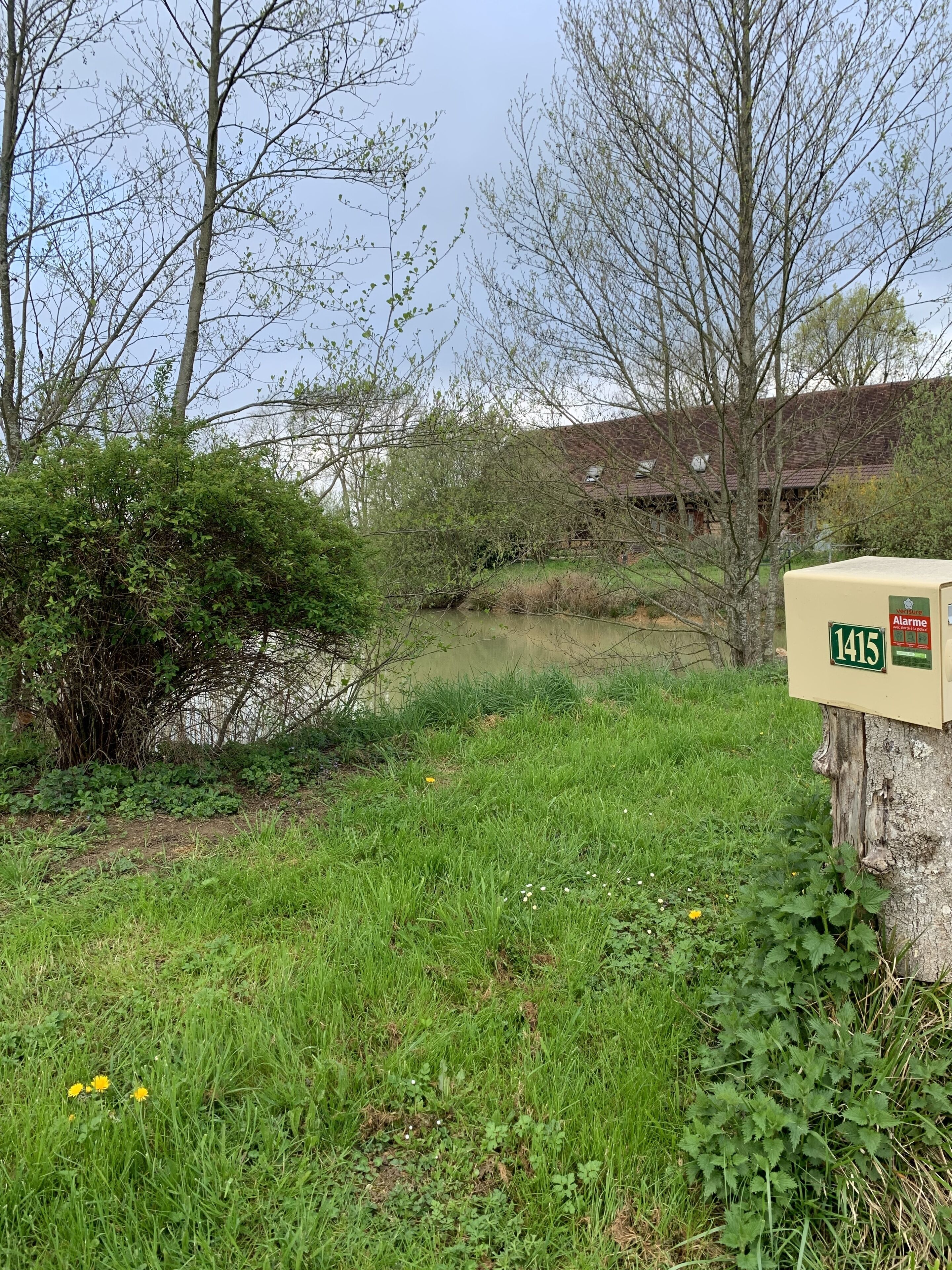 A mailbox with a house in the background.