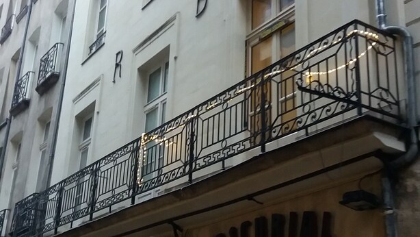 Un immeuble doté de balcons et d’une enseigne sur laquelle on peut lire « L’ESCURIAL ».
