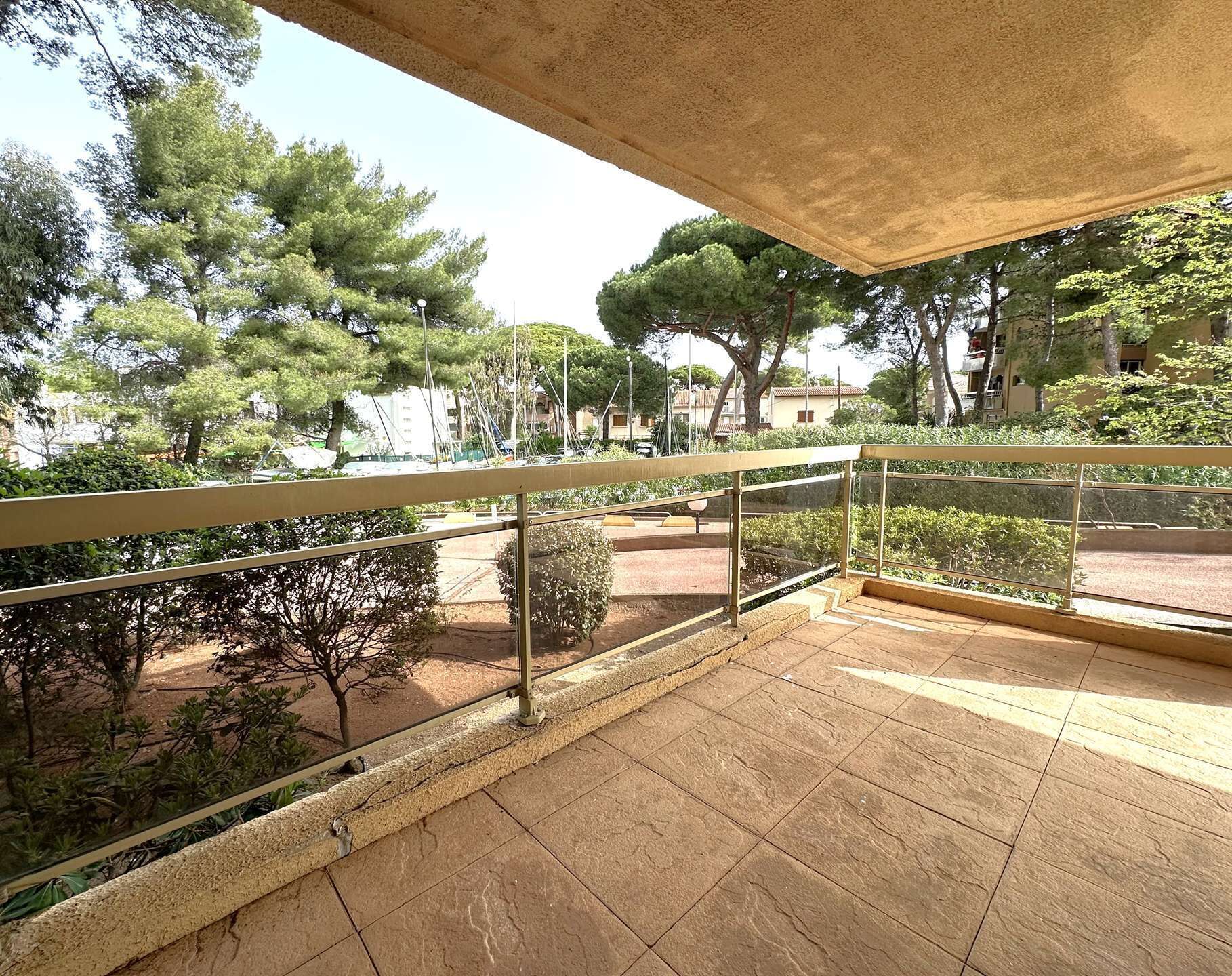 Un balcone con vista su alberi e un edificio in lontananza.