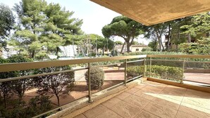 A balcony with a view of trees and a distant building. - Holiday rental, 2-bedroom apartment for 4 people, on the port of Hyères (HYERES PLAGE)