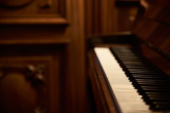 A close-up of a piano with a wooden finish and a glossy black and white keyboard.