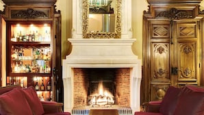 A grand room with a fireplace, ornate furniture, and a bar area. - Manoir de Contres (Le Controis en Sologne)