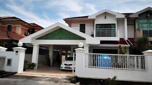 A two-story house with a covered driveway and a white fence. - Natol Homestay - Sydney Batu Kawa MJC New Townships (Kuching)