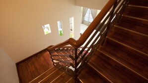 A wooden staircase with a handrail, leading to an upper floor. - Natol Homestay - Sydney Batu Kawa MJC New Townships (Kuching)