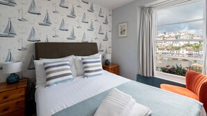 Una habitación de hotel con una cama grande, vistas de la ciudad y una ventana con cortinas.