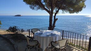 A table set for two with a view of the sea and a rocky outcrop in the distance. - APARTMENT NEW EXCEPTIONAL VIEW ON A COLINNE FACING THE SEA (a swimming pool) (benissa)