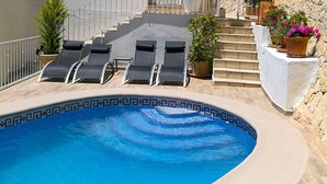 A swimming pool with lounge chairs, a staircase, and potted plants. - APARTMENT NEW EXCEPTIONAL VIEW ON A COLINNE FACING THE SEA (a swimming pool) (benissa)