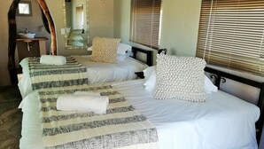 A room with three beds, a sink, and a mirror. - Torgos Lodge (Koes)