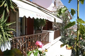 A hotel with a balcony, outdoor seating, and a sign that reads "HOTEL MATO." - Mato Hotel (Skiathos)