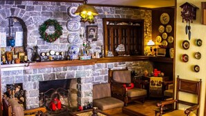 Una sala de estar acogedora con chimenea de piedra, muebles de madera y alfombra roja.
