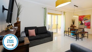 A modern living room with a sofa, a dining table, and a TV mounted on the wall. - C7 - 3 Bed Luxury Penthause by DreamAlgarve (Lagos)